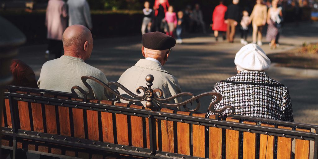elderly couple sitting on a park bench